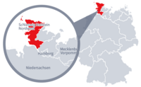 Diese Grafik zeigt eine Karte von Deutschland mit einer detaillierten Ansicht der Region Schleswig-Holstein-Nordwest. Schleswig-Holstein-Nordwest ist in Rot hervorgehoben und liegt im nördlichen Teil Deutschlands. Ein Lupensymbol vergrößert diesen Bereich, um die Lage genauer darzustellen.