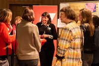 Eine Gruppe von Frauen steht vor einer Flipchart und unterhält sich angeregt.